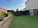 Private backyard featuring a brick retaining wall with manicured greenery and beautiful fencing at 2380 Cain Cir, Dacula, GA 30019