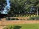 Terraced yard featuring manicured hedges, lush greenery, and a wooden fence for added privacy at 2380 Cain Cir, Dacula, GA 30019