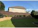 Spacious backyard featuring a brick retaining wall and lush greenery, enclosed by a wooden fence at 2380 Cain Cir, Dacula, GA 30019