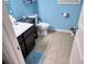 Charming, bright bathroom features a tile floor, blue walls, toilet, vanity, and a white door at 2380 Cain Cir, Dacula, GA 30019