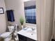 Cozy bathroom featuring a white vanity, matching toilet, and a blue striped shower curtain at 2380 Cain Cir, Dacula, GA 30019