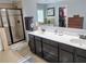 Bright bathroom featuring a glass enclosed shower, double sinks, and tile flooring at 2380 Cain Cir, Dacula, GA 30019