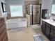 Bright bathroom featuring a tub, a glass enclosed shower, double sinks, and tile flooring at 2380 Cain Cir, Dacula, GA 30019