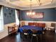 Dining room with blue walls, hardwood floors, coffered ceilings, chandelier, and a dark wood table with seating for six at 2380 Cain Cir, Dacula, GA 30019