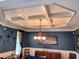 Dining room with a decorative trey ceiling, chandelier, and dark blue walls with wainscoting at 2380 Cain Cir, Dacula, GA 30019