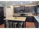 Updated kitchen featuring dark wood cabinets, stainless appliances, granite counters, and an island with seating at 2380 Cain Cir, Dacula, GA 30019