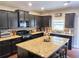 Well-equipped kitchen with dark wood cabinets, an island with seating, and granite countertops at 2380 Cain Cir, Dacula, GA 30019