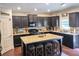 Spacious kitchen with island, dark wood cabinets, stainless appliances, and granite countertops at 2380 Cain Cir, Dacula, GA 30019