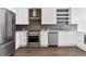 Modern kitchen featuring stainless steel appliances, white cabinetry, and stylish herringbone backsplash at 788 W Marietta Nw St # 1404, Atlanta, GA 30318