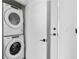 Modern laundry room with stacked washer and dryer, accented by stylish matte black hardware at 788 W Marietta Nw St # 1404, Atlanta, GA 30318