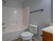 Bathroom with toilet, tub, shower with grey walls, and a wood vanity cabinet at 9187 Plantation Cir, Covington, GA 30014