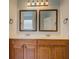 Bathroom vanity with double sinks, framed mirrors, and wooden cabinetry offering practical storage at 9187 Plantation Cir, Covington, GA 30014