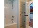 Bathroom featuring a tub and shower with tile walls, a white door, and hardwood floors at 9187 Plantation Cir, Covington, GA 30014
