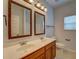 Bathroom with dual vanity sinks, framed mirrors, and toilet, enhancing a functional design at 9187 Plantation Cir, Covington, GA 30014