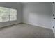 Bright bedroom featuring a window with blinds, light gray walls, and neutral carpet at 9187 Plantation Cir, Covington, GA 30014