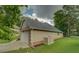 Side view of house featuring a two car garage and large yard at 9187 Plantation Cir, Covington, GA 30014