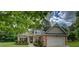 A charming single Gathering house featuring a brick facade, two car garage, and manicured lawn at 9187 Plantation Cir, Covington, GA 30014