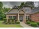 A brick home featuring manicured landscaping, dark shutters, and a concrete walkway at 9187 Plantation Cir, Covington, GA 30014