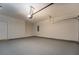 Spacious garage with overhead door and neutral colored walls and sealed concrete flooring at 9187 Plantation Cir, Covington, GA 30014