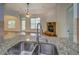 Modern kitchen sink with stainless steel fixtures and a view into the living room at 9187 Plantation Cir, Covington, GA 30014