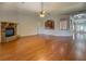 Open-concept living room with hardwood floors, stone fireplace, and access to the kitchen and dining room at 9187 Plantation Cir, Covington, GA 30014