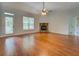 Spacious living room featuring hardwood floors, a ceiling fan, and a stone fireplace at 9187 Plantation Cir, Covington, GA 30014