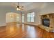 Bright living room with hardwood floors, a stone fireplace, and windows offering natural light at 9187 Plantation Cir, Covington, GA 30014