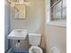 Compact bathroom featuring a sink, toilet, shower with blue tile floor and a mirrored medicine cabinet at 1513 Dupree Rd, Woodstock, GA 30189