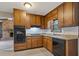 Kitchen with wood cabinets, granite countertops, and black appliances for a classic look at 1513 Dupree Rd, Woodstock, GA 30189