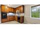 Kitchen featuring wood cabinets, granite countertops, and black appliances for a practical and stylish cooking space at 1513 Dupree Rd, Woodstock, GA 30189