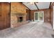 Bright living room featuring a brick fireplace, wood-paneled walls, a ceiling fan, and direct access to the outdoors at 1513 Dupree Rd, Woodstock, GA 30189