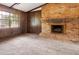Spacious living room with brick fireplace, wood paneling, and ample natural light for a cozy atmosphere at 1513 Dupree Rd, Woodstock, GA 30189