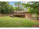 Back exterior of a brick home featuring a deck overlooking a spacious backyard at 1693 Alderbrook Ne Rd, Atlanta, GA 30345
