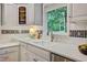 Bright kitchen features white cabinets, designer backsplash, and a stainless steel dishwasher beneath a large sink at 1693 Alderbrook Ne Rd, Atlanta, GA 30345
