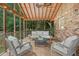 Relaxing screened porch features comfortable furniture, string lights, and brick accent wall at 1693 Alderbrook Ne Rd, Atlanta, GA 30345