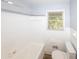 White bathroom with white tiled walls, a tub, and a window at 5952 Medlock Ave, Austell, GA 30106