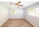 Bedroom featuring neutral paint, wood-look floors, two windows, and a ceiling fan at 5952 Medlock Ave, Austell, GA 30106