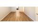 Hallway with wood floors has a door on the right, white walls, and a view into another room at 5952 Medlock Ave, Austell, GA 30106