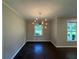 Charming dining room with hardwood floors, a modern chandelier, and large windows at 2545 Glenrock Dr, Decatur, GA 30032