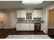 Updated kitchen featuring white cabinets, granite countertops, stainless steel dishwasher, and dark wood floors at 2545 Glenrock Dr, Decatur, GA 30032