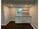 Kitchenette featuring custom cabinets, shelves, granite countertops, plus dark wood floors at 2545 Glenrock Dr, Decatur, GA 30032