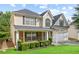View of the charming two-story home featuring manicured lawn, covered porch, and a two-car garage at 273 Baywood Xing, Hiram, GA 30141