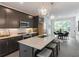A sleek kitchen with stainless steel appliances, dark cabinetry, an island with bar stools, and updated countertops at 371 Grant Cir # 1813, Atlanta, GA 30315