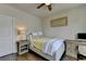 Neutral bedroom with a ceiling fan features a comfy bed, desk, and a white door at 767 Farmstead Rd, Suwanee, GA 30024