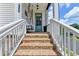 Inviting front porch with brick stairs, swing bench and a blue front door at 767 Farmstead Rd, Suwanee, GA 30024