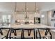 The kitchen offers barstool seating at the large island with modern light fixtures and stainless appliances at 767 Farmstead Rd, Suwanee, GA 30024