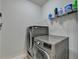 Laundry room with gray front load washer and dryer and wire rack shelving at 767 Farmstead Rd, Suwanee, GA 30024