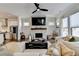 Bright living room with a stone fireplace, large windows, and open access to the kitchen at 767 Farmstead Rd, Suwanee, GA 30024