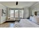 Stylish main bedroom features hardwood floors, ceiling fan, windows, and chaise lounge at 767 Farmstead Rd, Suwanee, GA 30024