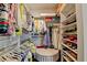 Bright walk-in closet featuring custom shelving, hanging rods, and central ottoman at 767 Farmstead Rd, Suwanee, GA 30024